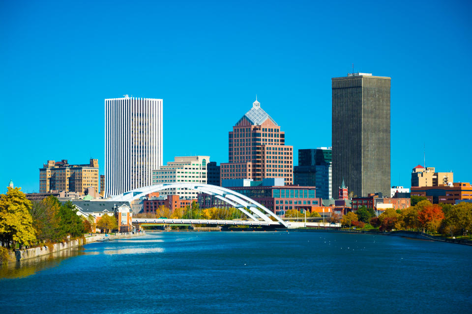 Downtown Rochester skyline with a bridge, and with the Genesee River in the foreground.