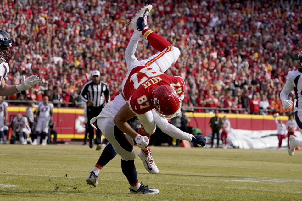 Kansas City Chiefs tight end Travis Kelce (87) is upended trying to leap over Denver Broncos cornerback Damarri Mathis after catching a pass during the first half of an NFL football game Sunday, Jan. 1, 2023, in Kansas City, Mo. (AP Photo/Ed Zurga)
