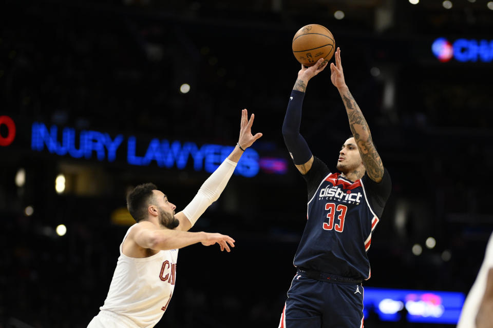 Washington Wizards forward Kyle Kuzma (33) shoots against Cleveland Cavaliers guard Max Strus (1) during the first half of an NBA basketball game Wednesday, Feb 7, 2024, in Washington. (AP Photo/Nick Wass)