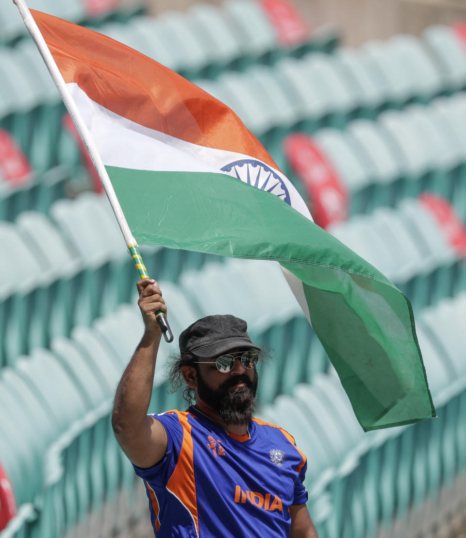 Indian fan waves a flag ahead of the one day international cricket match between India and Australia at the Sydney Cricket Ground in Sydney, Australia, Sunday, Nov. 29, 2020. (AP Photo/Rick Rycroft)
