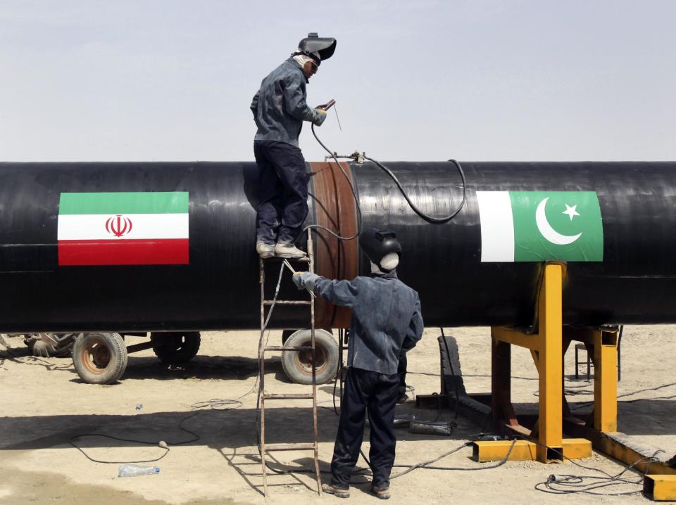 FILE - In this March 11, 2013 file photo, Iranian workers weld two gas pipes together at the start of construction on a pipeline to transfer natural gas from Iran to Pakistan, in Chabahar, southeastern Iran, near the Pakistani border. For many business leaders, Iran is a mouthwatering emerging market, and they could soon find themselves heading to Iran to secure new deals following the suspension of the first international sanctions. (AP Photo/Vahid Salemi, File)