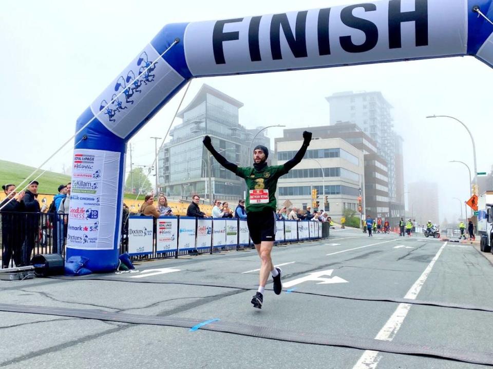 Nathan Ryan O'Hehir raises his arms in triumph as he wins the Blue Nose Marathon in Halifax on Sunday in a time of 2:42. (Haley Ryan/CBC - image credit)