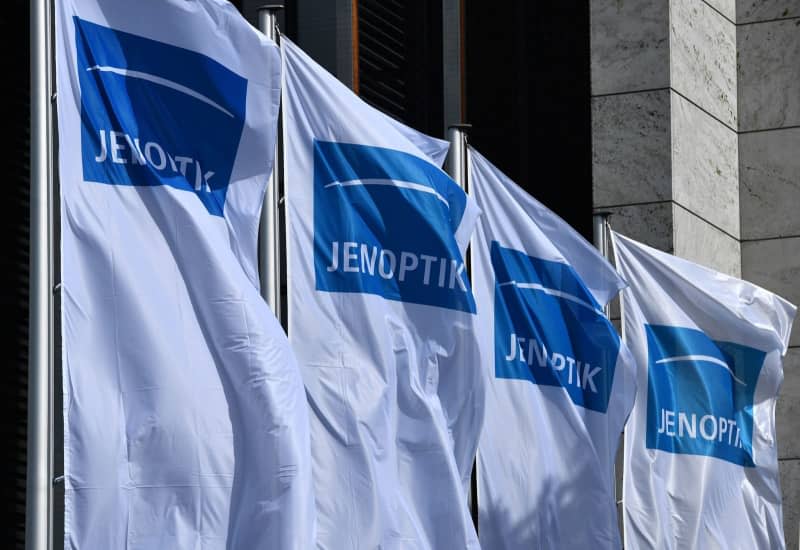 Flags with the Jenoptik AG logo fly in front of the Weimarhalle during the company's general meeting. Martin Schutt/dpa-Zentralbild/dpa