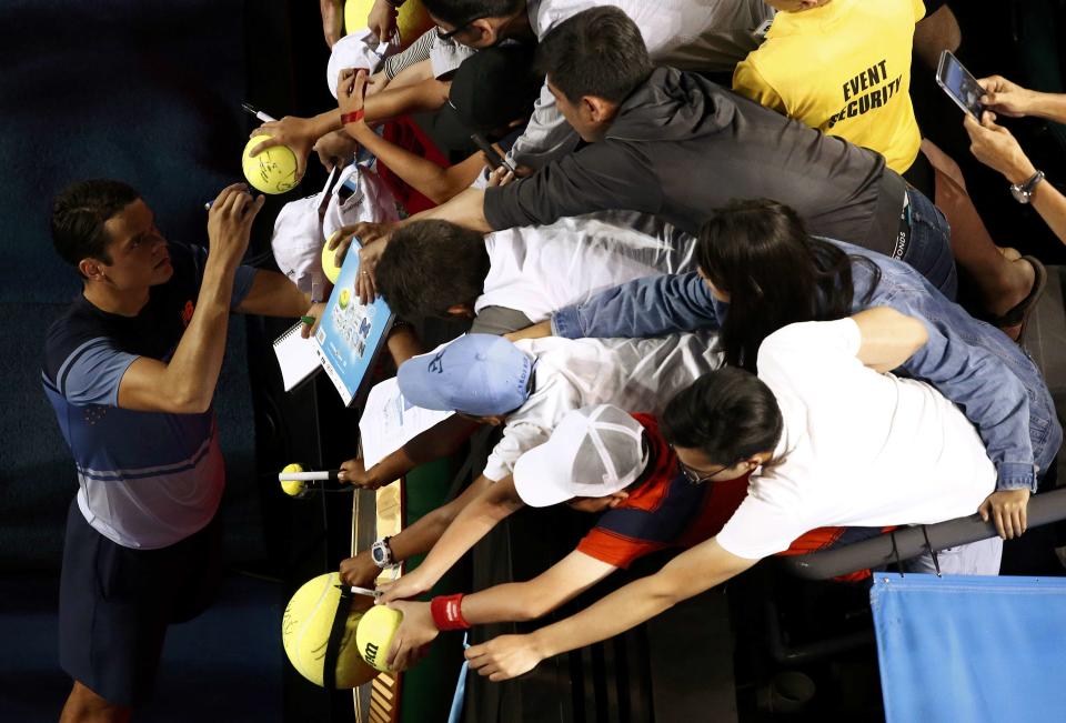 Canada's Raonic signs autographs after winning his quarter-final match against France's Monfils at the Australian Open tennis tournament at Melbourne Park