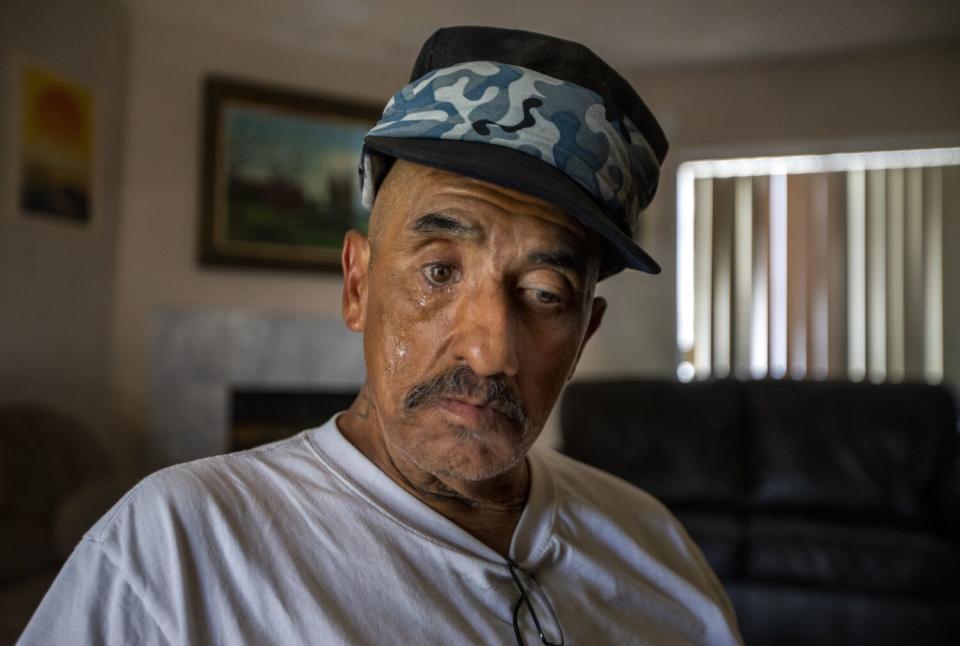 A man in a white T-shirt and camouflage hat