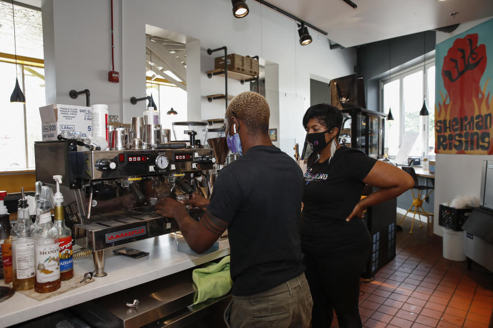 Baboonie Tatum, owner of the Rise &amp; Grind Cafe, checks on an employee inside her coffee shop in Milwaukee on Aug. 15, 2020. (Photo: KAMIL KRZACZYNSKI via Getty Images)