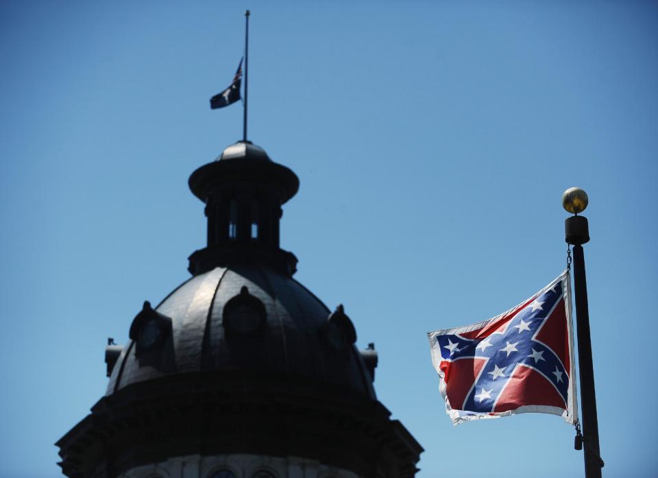 FILE - In a Friday, June 19, 2015 file photo, the Confederate flag flies near the South Carolina Statehouse, in Columbia, S.C. For 15 years, South Carolina lawmakers refused to consider removing the Confederate flag from Statehouse grounds, but opinions changed within five days of the massacre of nine people at Emanuel African Methodist Episcopal church in Charleston, as a growing tide of Republicans joined the call to remove the battle flag from a Confederate monument in front of the Statehouse and put it in a museum., File (AP Photo/Rainier Ehrhardt, File)