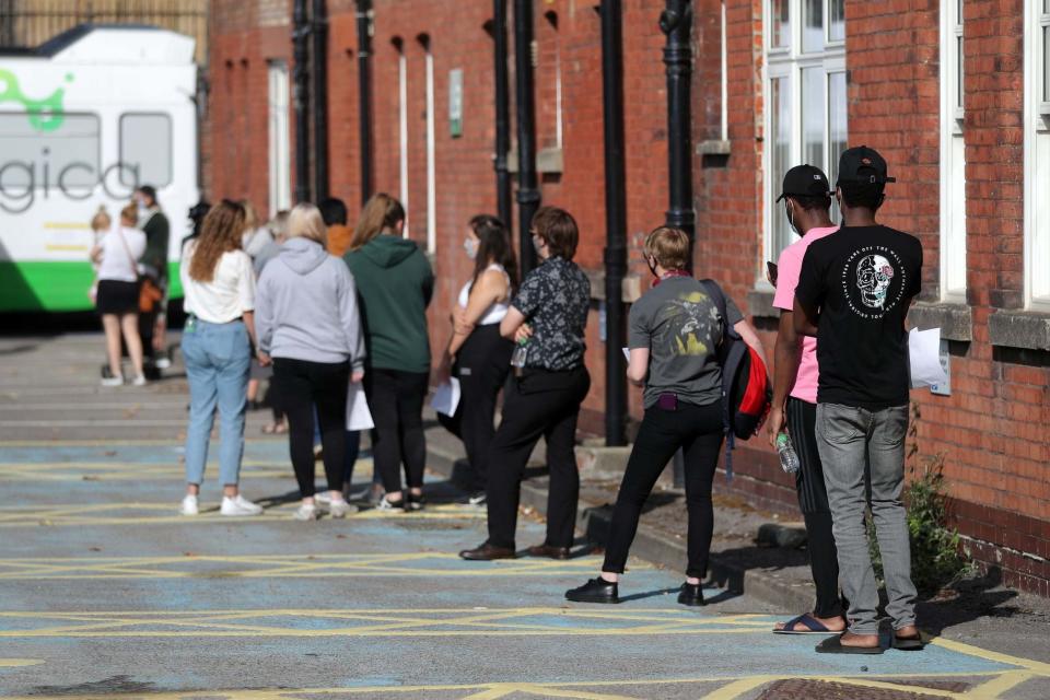 Students and staff queue up outside a mobile coronavirus testing unit for asymptomatic staff and students set up in a car park at the University of Portsmouth: PA