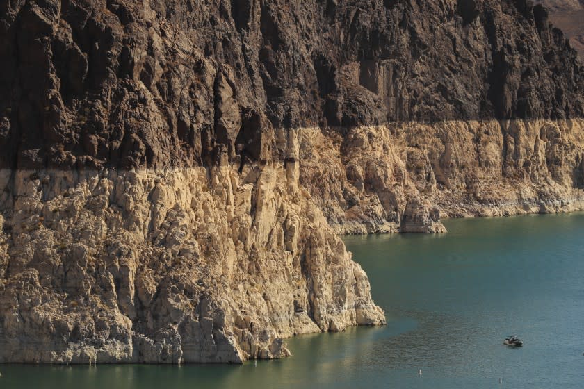 Lake Mead, NV - June 28: A boater gets an up-close view the "bathtub ring" that is visible at low water levels and is the result of the deposition of minerals on previously submerged surfaces while touring the front of Hoover Dam, which sits on the border of Nevada and Arizona. Photo taken at Lake Mead, Nevada Monday, June 28, 2021. Lake Mead is at its lowest level in history since it was filled 85 years ago, Monday, June 28, 2021. The ongoing drought has made a severe impact on Lake Mead and a milestone in the Colorado River's crisis. High temperatures, increased contractual demands for water and diminishing supply are shrinking the flow into Lake Mead. Lake Mead is the largest reservoir in the U.S., stretching 112 miles long, a shoreline of 759 miles, a total capacity of 28,255,000 acre-feet, and a maximum depth of 532 feet. (Allen J. Schaben / Los Angeles Times)