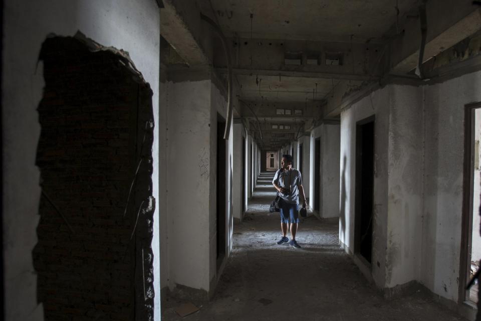 A visitor walks inside an abandoned building in Bangkok