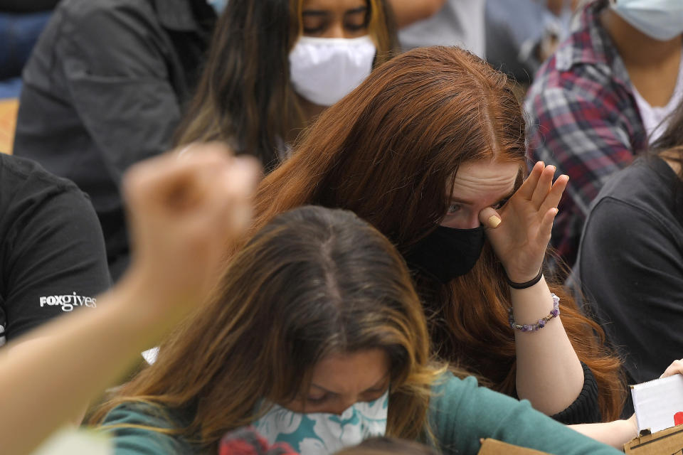 A demonstrator wipes tears from her eyes during 8 minutes and 46 seconds of silence during a protest, Saturday, June 6, 2020, in Simi Valley, Calif., over the death of George Floyd. Floyd died after he was restrained in police custody on Memorial Day in Minneapolis. (AP Photo/Mark J. Terrill)