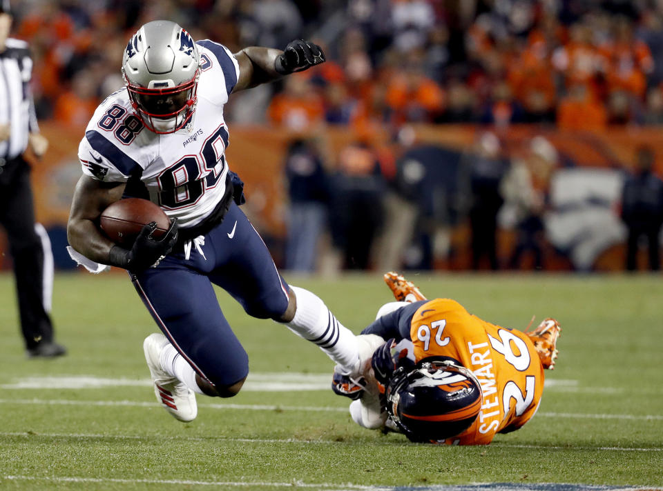 FILE – In this Sunday, Nov. 12, 2017, file photo, New England Patriots tight end Martellus Bennett (88) is tripped up by Denver Broncos free safety Darian Stewart (26) during the first half of an NFL football game in Denver. Bennett is still coming to terms with how his Green Bay tenure ended. But he says being back in familiar surroundings is helping him to deal with it. (AP Photo/Jack Dempsey, File)