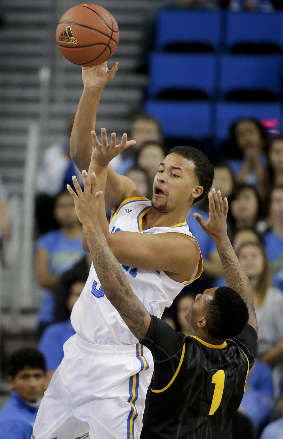 UCLA guard Kyle Anderson, left, passes over Arizona State guard Jahii Carson during the first half of an NCAA college basketball game in Los Angeles, Sunday, Jan. 12, 2014. (AP Photo/Chris Carlson)