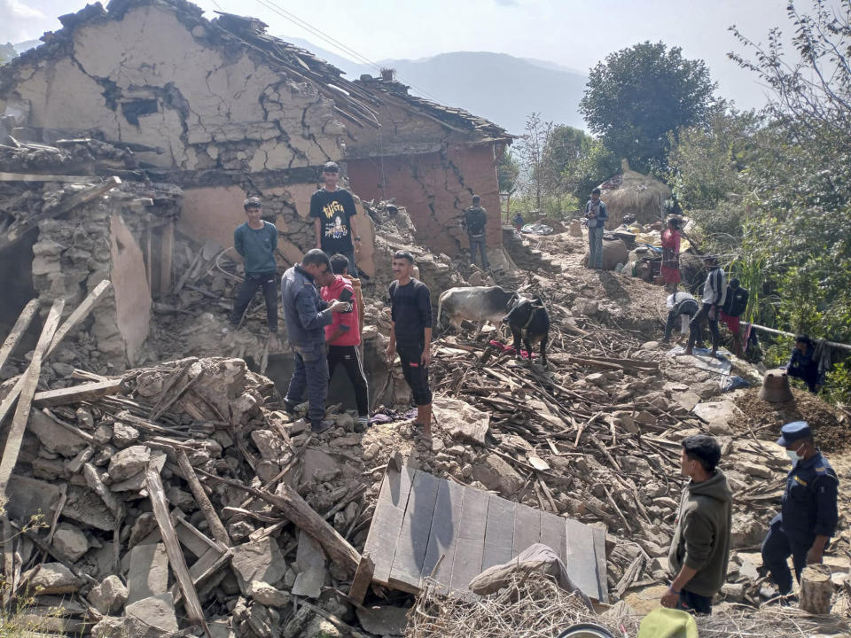 Nepalese villagers stand amidst the debris of their mudhouses after an earthquake in Doti district, Nepal, Wednesday, Nov.9, 2022. A government official said the quake has killed at least six people while they were asleep in their houses in a remote, sparsely populated mountain village. (AP Photo/Dil Bahadur Singh)