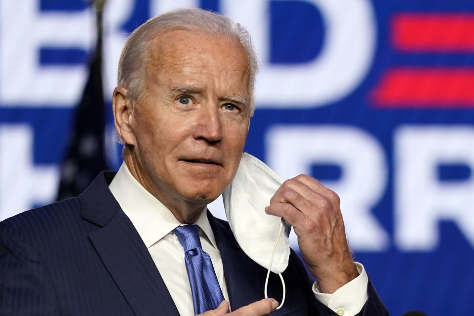 Democratic presidential candidate former Vice President Joe Biden takes his face mask off as he arrives to speak speaks Friday, Nov. 6, 2020, in Wilmington, Del. (AP Photo/Carolyn Kaster)