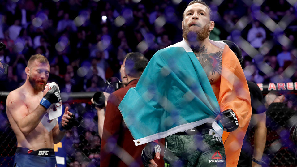 Conor McGregor walks across the Octagon after defeating Donald Cerrone (L) in a welterweight bout during UFC246 at T-Mobile Arena on January 18, 2020.