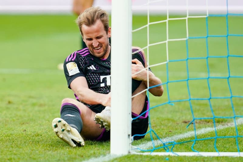 Munich's Harry Kane sits on the pitch with a pained face during the German Bundesliga soccer match between Darmstadt 98 and Bayern Munich at Merck Stadium at Böllenfalltor.  Harry Kane has returned to Bayern Munich team training from an ankle injury amid hopes that he can feature in Saturday's big Bundesliga match against Borussia Dortmund. Uwe Anspach/dpa