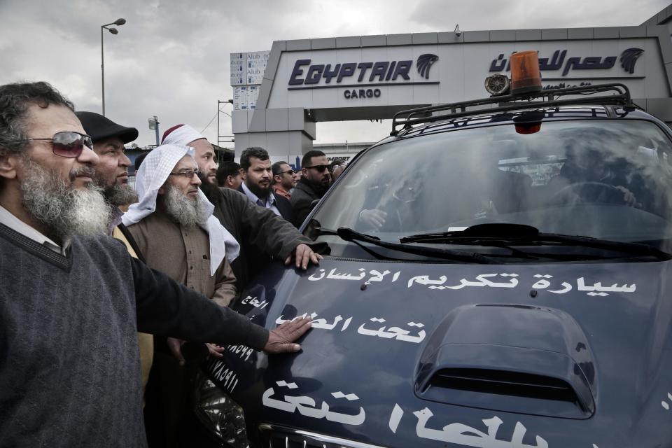 Relatives and friends of Sheik Omar Abdel-Rahman, who was convicted of plotting terror attacks in New York City in the decade before 9/11, gather around the vehicle carrying his coffin at Cairo International Airport, in Egypt, Wednesday, Feb. 22, 2017. Abdel-Rahman, blind since infancy from diabetes, had diabetes and coronary artery disease, died Saturday at the Federal Correction Complex in Butner, North Carolina, said its acting executive assistant, Kenneth McKoy. The inmate spent seven years at the prison medical facility while serving a life sentence. (AP Photo/Nariman El-Mofty)