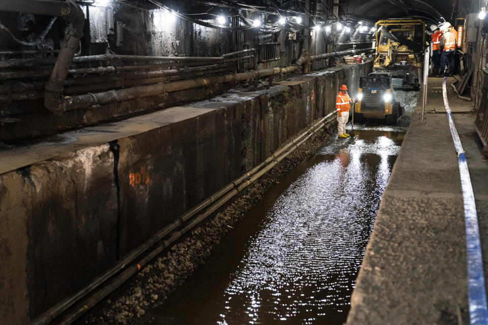 Amtrak workers perform tunnel repairs to a partially flooded train track bed, Saturday, March 20, 2021, in Weehawken, N.J. With a new rail tunnel into New York years away at best, Amtrak is embarking on an aggressive and expensive program to fix a 110-year-old tunnel in the interim. (AP Photo/John Minchillo)