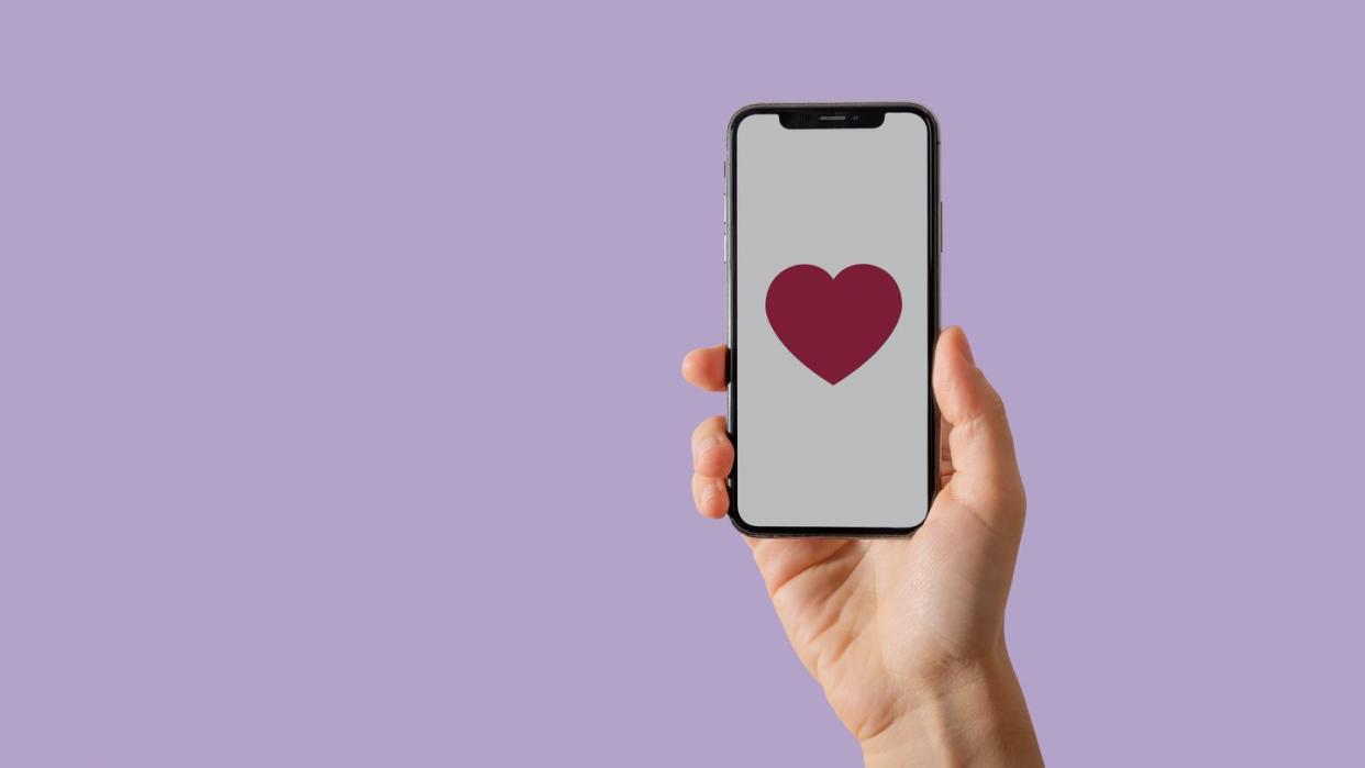 hand with smartphone, heart on screen