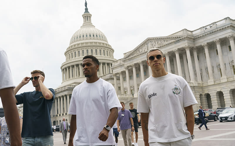 Arsenal's Jurrien Timber, center, and Leandro Trossard, right, are seen during a tour of the Capitol. Behind them is the Capitol dome.