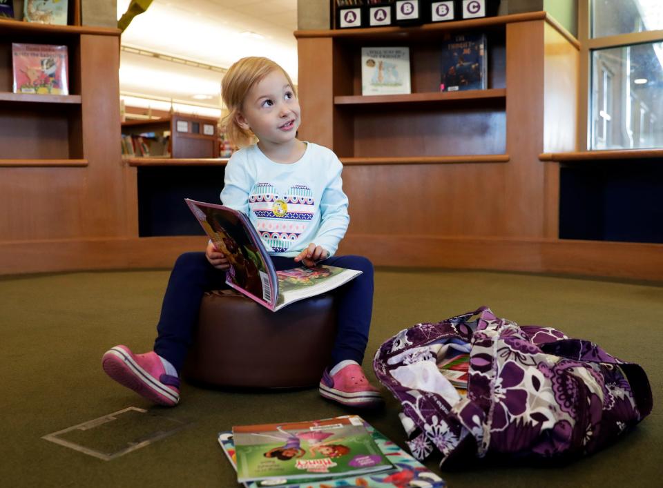 Lenni Marto, 3, of Pulaski looks at books while visiting the Brown County Library's Weyers-Hilliard Branch in Howard.