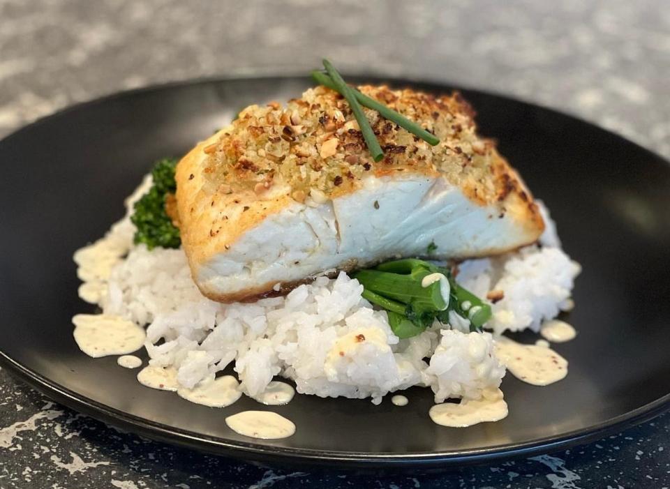 Pan-seared almond encrusted halibut, served with jasmine rice and sauteed broccolini in a whole grain mustard cream sauce, at Point Lobster Bar and Grill in Point Pleasant Beach.