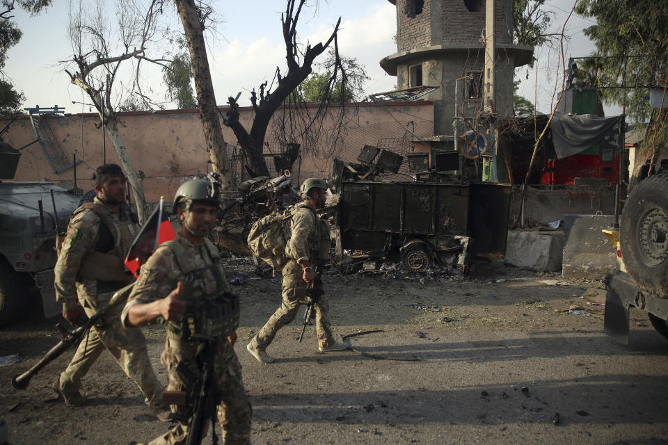 File - In this Monday, Aug. 3, 2020 file photo, Afghan security personnel gather in front of a prison after an attack in the city of Jalalabad, east of Kabul, Afghanistan. Afghanistan has been at war for more than 40 years, first against the invading Soviet army that killed more than 1 million people, then feuding mujahedin groups in a bitter civil war followed by the repressive Taliban rule and finally the latest war that began after the 2001 U.S.-led coalition invasion that toppled the Taliban government. (AP Photo/Rahmat Gul, File)