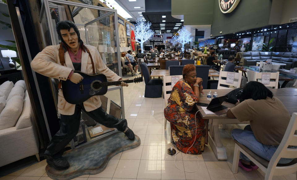 FILE - Houston residents Janice Taylor, left, and her daughter Janell spend time at Gallery Furniture, which is being used as a temporary shelter, to cool off and charge their electronic devices, in Houston, Tuesday, July 9, 2024. The effects of Hurricane Beryl left most in the area without power. (AP Photo/Eric Gay)