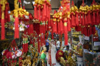 A buyer checks lucky charms for the coming Chinese New Year at Binondo district, said to be the oldest Chinatown in the world, in Manila, Philippines on Monday, Feb. 5, 2024. Crowds are flocking to Manila's Chinatown to usher in the Year of the Wood Dragon and experience lively traditional dances on lantern-lit streets with food, lucky charms and prayers for good fortune. (AP Photo/Aaron Favila)