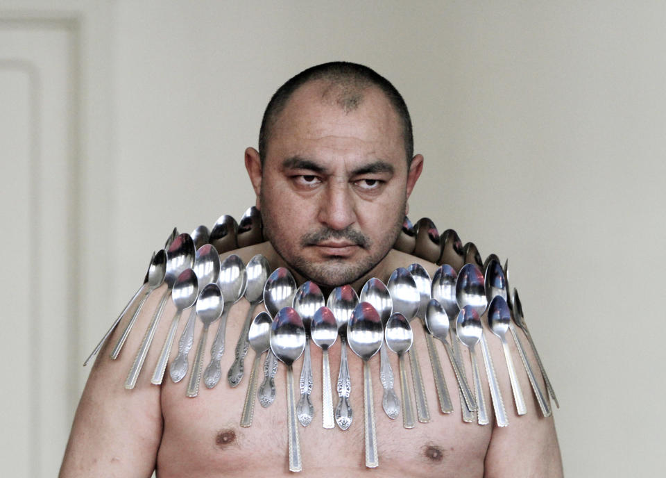 Etibar Elchiyev poses with 50 metal spoons magnetized to his body during an attempt to break the Guinness World Record for "Most spoons on a human body" in Tbilisi December 14, 2011. REUTERS/David Mdzinarishvili