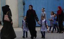 Women walk with their children on the first day of the new school year at the United-Nation run Elementary School at the Shati refugee camp in Gaza City, Saturday, Aug. 8, 2020. Schools run by both Palestinian government and the U.N. Refugee and Works Agency (UNRWA) have opened almost normally in the Gaza Strip after five months in which no cases of community transmission of the coronavirus had been recorded. (AP Photo/Adel Hana)