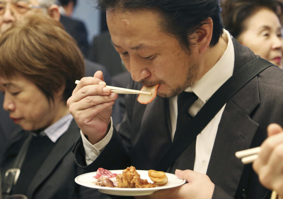 A supporter of Japan's whaling eats a slice of whale meat during the 26th whale meat tasting event in Tokyo Tuesday, April 15, 2014. Hundreds of Japanese pro-whaling officials, lawmakers and lobby groups vowed to protect whale hunts despite the world court ruling that ordered the country’s Antarctic research culls must be stopped. (AP Photo/Koji Sasahara)