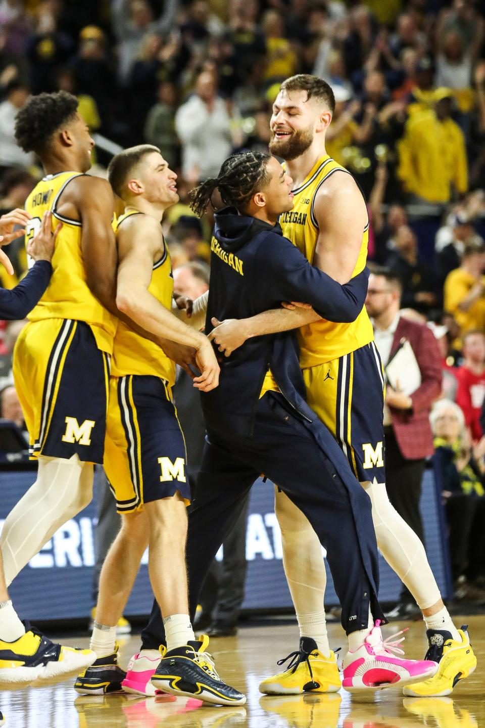 (From left) Michigan forward Jace Howard, guard Joey Baker and guard Jett Howard celebrate with center Hunter Dickinson in overtime of U-M's 87-79 win over Wisconsin on Sunday, Feb. 26, 2023, at Crisler Center.