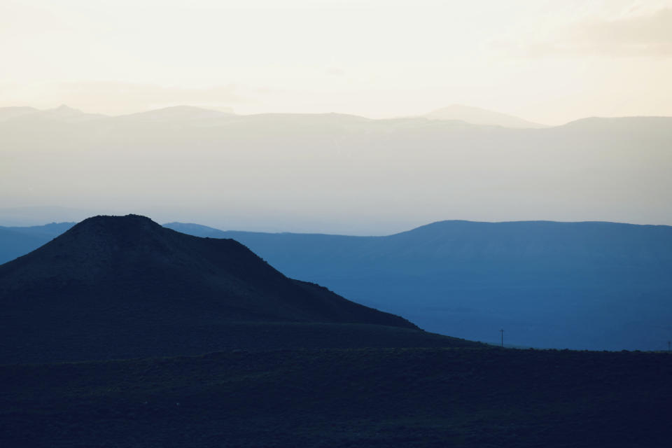 This Wednesday, June 15, 2022 photo shows hills outside Cody, Wyo. The region is ground zero in the conflict between golden eagles and wind farms, which both find homes in areas where there are strong winds. As wind turbines proliferate, scientists say deaths from collisions could drive down golden eagle numbers considered stable at best and likely to drop in some areas. (AP Photo/Emma H. Tobin)