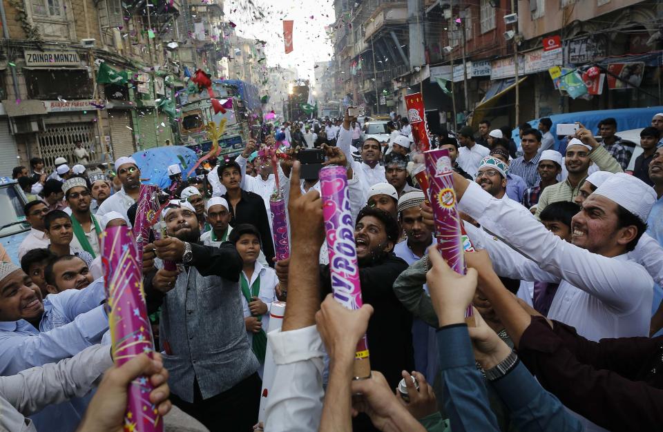 People fire confetti poppers as they participate in a procession to mark Eid-e-Milad-ul-Nabi, or birthday celebrations of Prophet Mohammad in Mumbai