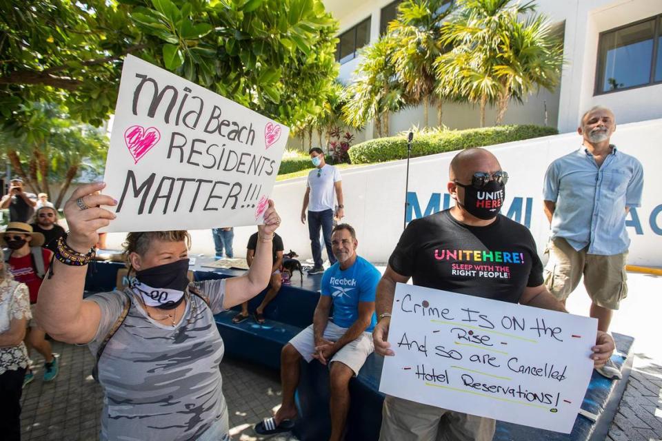 Helena Velasquez, left, holds a sign as Miami Beach residents gathered outside City Hall to protest the city’s handling of spring break on Saturday, March 27, 2021.