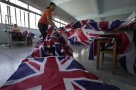 Workers produce British flags at the Shaoxing Chuangdong Tour Articles Co. factory in Shaoxing, in eastern China's Zhejiang province, Friday, Sept. 16, 2022. Ninety minutes after Queen Elizabeth II died, orders for thousands of British flags started to flood into the factory south of Shanghai. (AP Photo/Ng Han Guan)