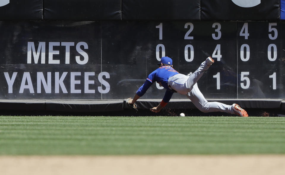 New York Mets right fielder Michael Conforto misjudges a ball hit by New York Yankees' Brett Gardner for an RBI triple during the fifth inning in the first game of a baseball doubleheader Tuesday, June 11, 2019, in New York. (AP Photo/Frank Franklin II)