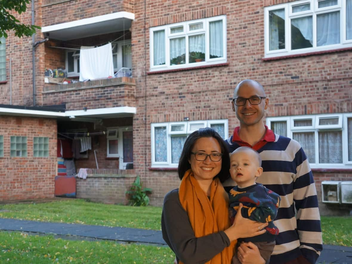 Canadian Emi Morimoto, her husband Thomas Walker, and their 16 month old son, Ripley, in front of their building. They bought the 675 sq. ft. two- bedroom for £315,000, or about $530,000.  (Submitted by Emi Morimoto - image credit)