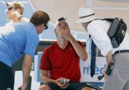 Frank Dancevic of Canada receives medical attention during his men's singles match against Benoit Paire of France at the Australian Open 2014 tennis tournament in Melbourne January 14, 2014. REUTERS/Brandon Malone (AUSTRALIA - Tags: SPORT TENNIS)