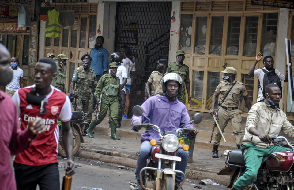 FILE - In this Thursday, Nov. 19, 2020 file photo, Ugandan security forces patrol on a street after protests over the arrest of opposition presidential candidate Bobi Wine, in Kampala, Uganda. The United States said Friday, April 16, 2021 that it is imposing visa restrictions on "those believed to be responsible for, or complicit in, undermining the democratic process in Uganda," including during the election in January and the campaign period. (AP Photo, File)