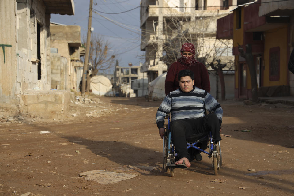 Mother pushes Sidhu Fahad who lost his leg during the February 2023 earthquake in Jinderis, Syria, on Jan. 27, 2024. (AP Photo/Omar Albam)