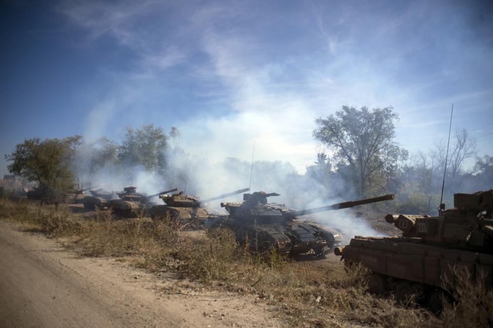 FILE - A column of Pro-Russian rebel tanks prepare to move from the line of separation between rebel-held territory and Ukraine-held territory near Oleksandrivka, Luhansk region, eastern Ukraine, Saturday, Oct. 3, 2015. A peace agreement for eastern Ukraine has remained stalled for years, but it has come into the spotlight again amid a Russian military buildup near Ukraine that has fueled invasion fears. On Thursday, Feb. 10, 2022 presidential advisers from Russia, Ukraine, France and Germany are set to meet in Berlin to discuss ways of implementing the deal that was signed in the Belarusian capital of Minsk in 2015. (AP Photo, File)