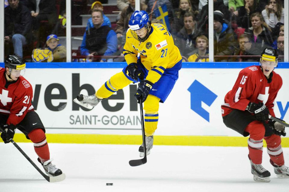 Sweden's Karlsson is in the air after a tackle from Switzerland's Herzog during their IIHF World Junior Hockey Championship ice hockey game in Malmo