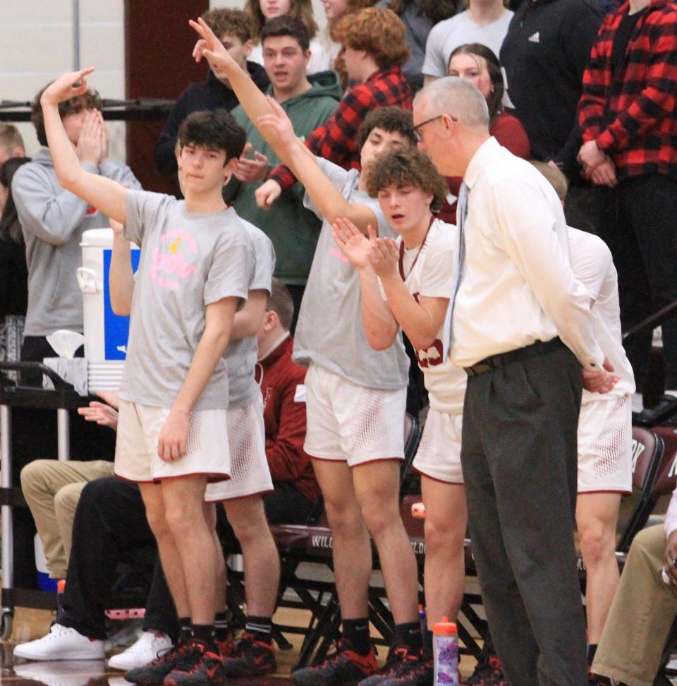 Newark senior Tucker Anderson, left, sophomore Kalen Winbush, center, and freshman Ty Gilbert, right, celebrate a 3-pointer against Central Crossing at Jimmy Allen Gymnasium on Friday, Feb. 3, 2023. The host Wildcats beat the Comets 57-31.