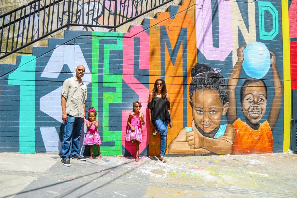 The author and her family standing in front of colorful street art in Medellin, Colombia in 2018.