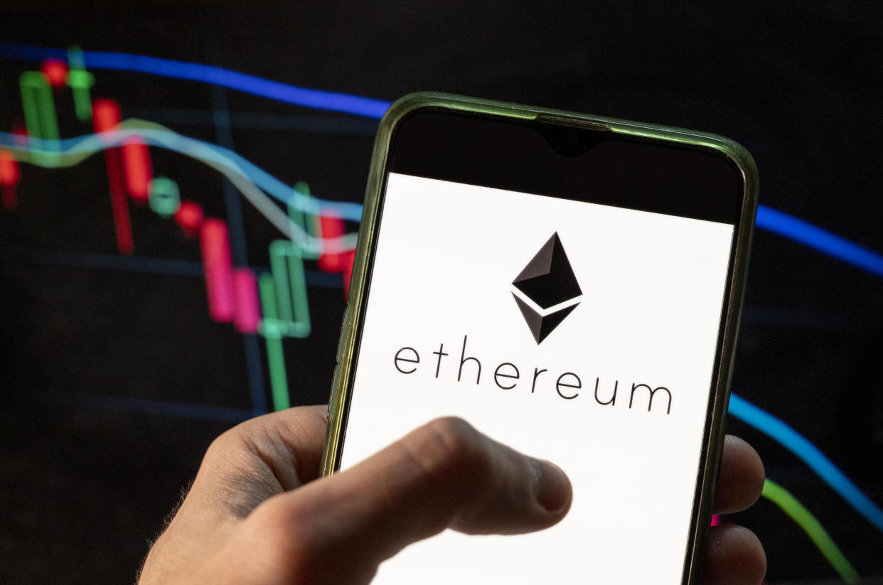 CHINA - 2021/12/09: In this photo illustration the cryptocurrency generated by the Ethereum (Ether, ETH) logo seen displayed on a smartphone with an economic stock exchange index graph in the background. (Photo Illustration by Chukrut Budrul/SOPA Images/LightRocket via Getty Images)