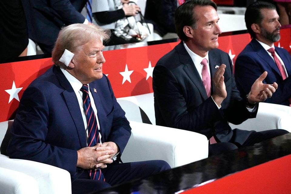 Donald Trump sits next to Virginia Glenn Youngkin and Donald Trump Jr. during the third day of the Republican National Convention at Fiserv Forum. The third day of the RNC focused on foreign policy and threats.