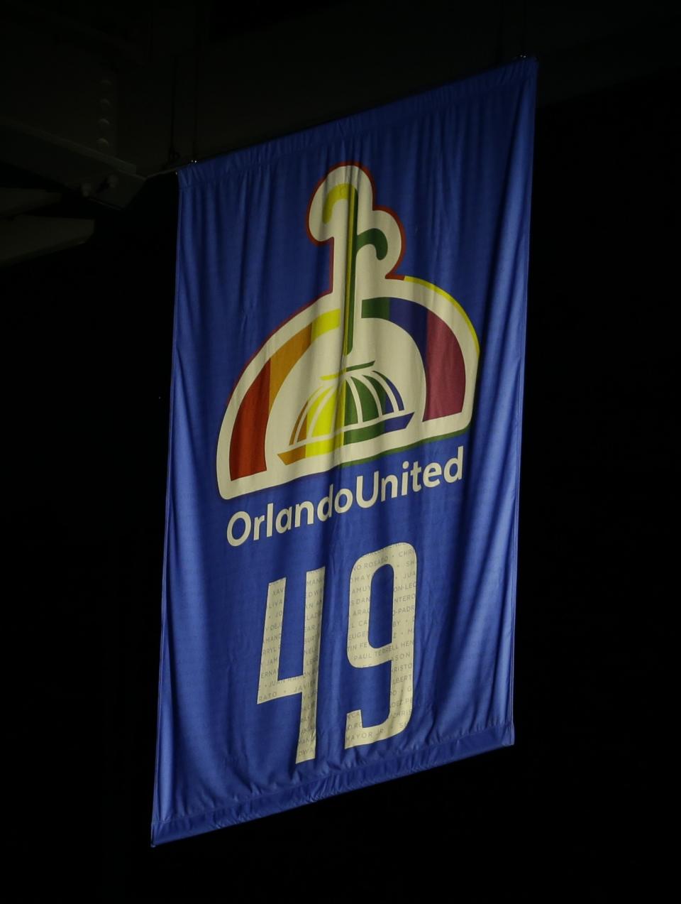 A banner printed with the names of the Pulse nightclub shooting victims and 49, the number of people who died in the shooting, is unveiled at Amway Center. (AP)